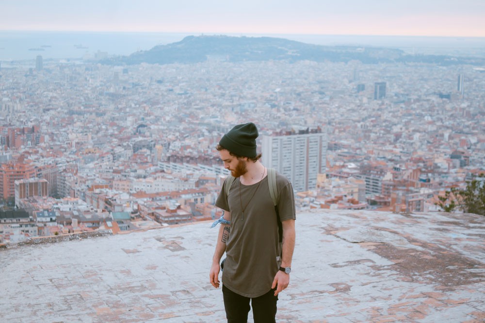 fotografía de un chico con un gorro negro en los búnkers de Barcelona y detrás la ciudad